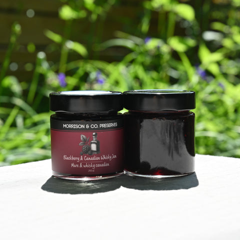 Two jars of Morrison & Co. preserves with a blurred green outdoor background