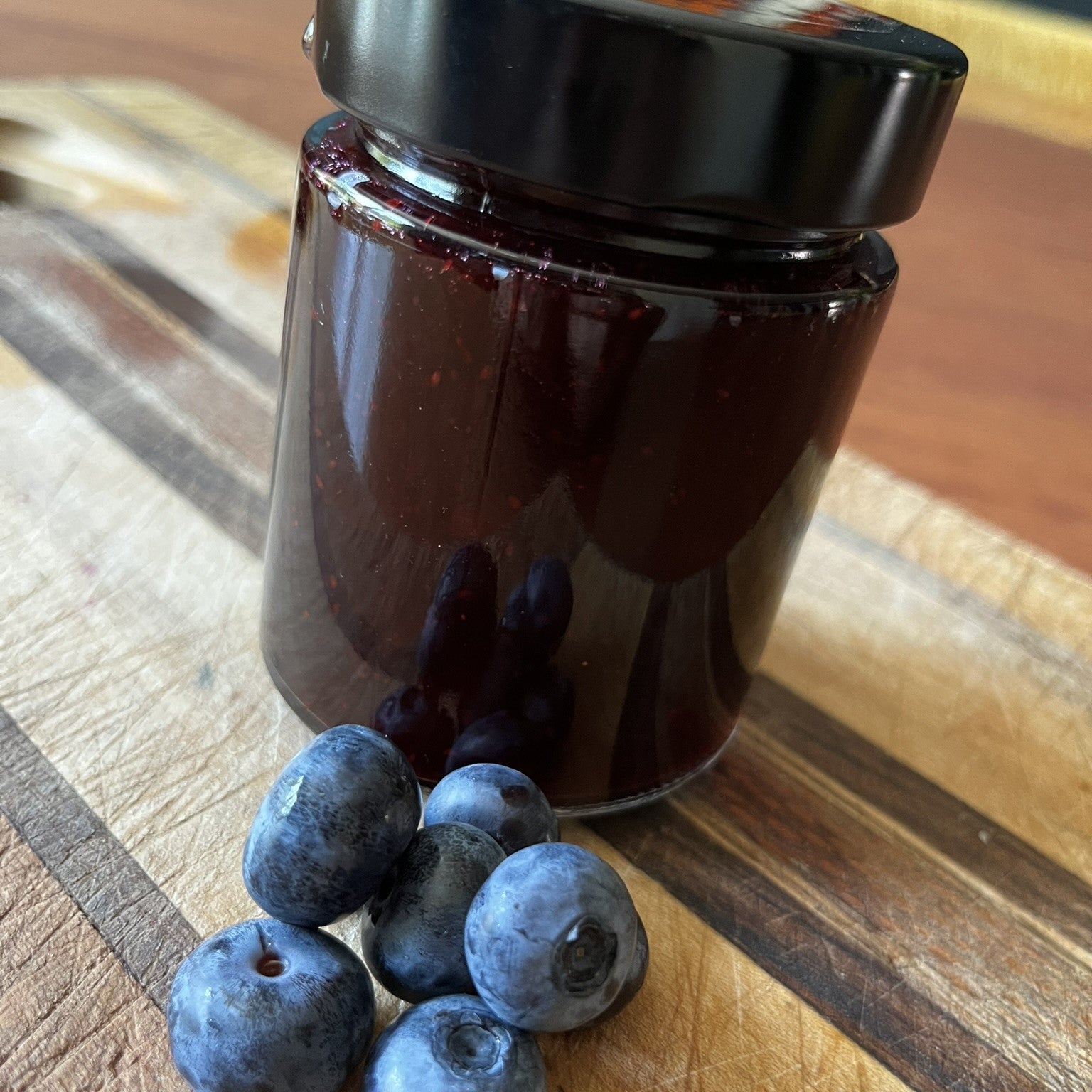 One jar of blueberry and gin jam with blueberries in the picture