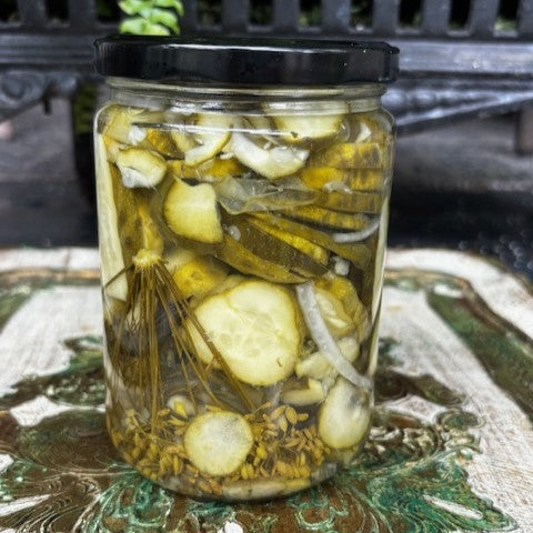 Jar of sliced dill pickles on a decorative surface