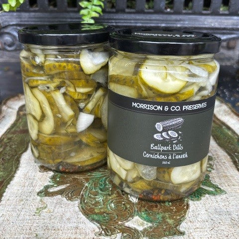 Two jars of Morrison & Co ballpark dill pickles with a label on a decorative surface