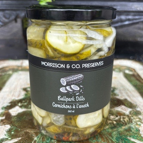 Jar of ballpark dill pickles with a black lid and label on a decorative surface