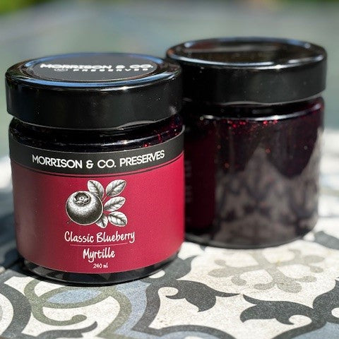 Two jars of Morrison & Co. Preserves Classic Blueberry on a patterned surface.